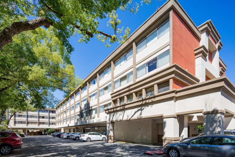 A side view of a former extended stay hotel and parking lot, converted to multi family apartments